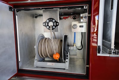 A storage compartment of a field decontamination vehicle shows decontamination equipment. 