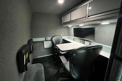 A soundproof command center with black chairs, white desktop and gray walls.